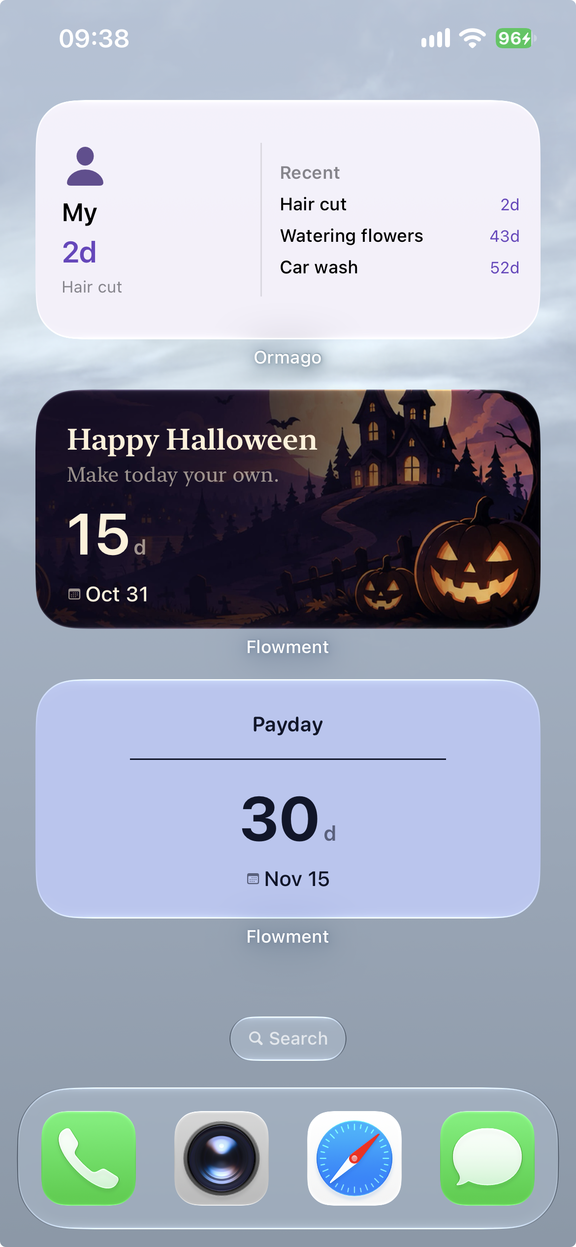 真实 iPhone 桌面：Flowment 万圣节小组件显示 Happy Halloween、15d 和 Oct 31，上下保留日常小组件
